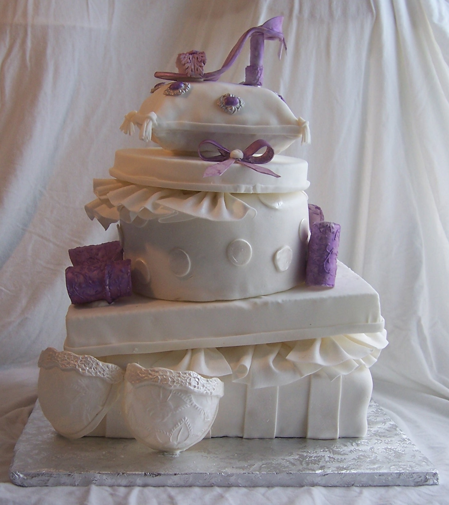 Metta's Bridal Shower cake of Stacked presents, purple shoe, purple bows,  white gumpaste bra