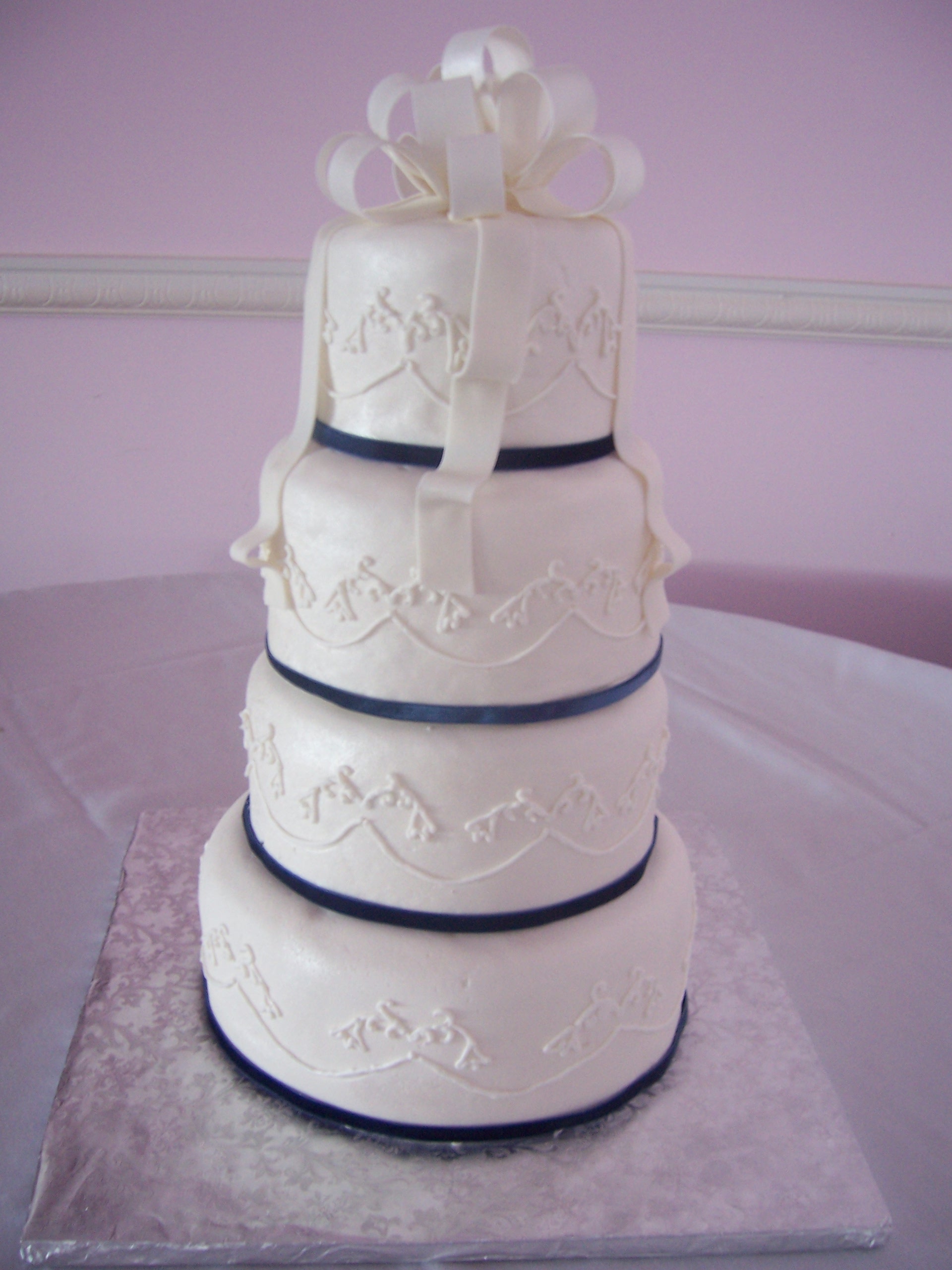 Wedding cake covered with white fondant, purple-blue fabric ribbon ... Wedding cake covered with white fondant, purple-blue fabric ribbon ...