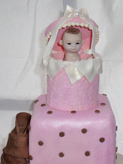 Baby Shower Tiered cake close up of handmade, edible top decoration that is similar to a Precious Moments figurine