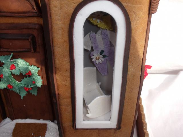 close up of baby shop window with gumpaste cradle and gumpaste clothes