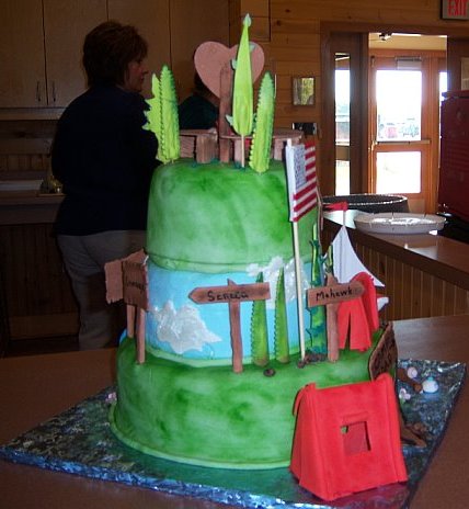 View of back of cake which had rustic signs labeled with camp names.