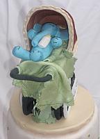 Old fashioned or old time baby carriage with blue gumpaste baby elephant inside