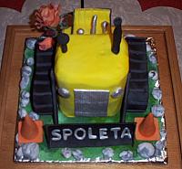 Bulldozer Cake front view, cake covered in fondant. Cake complete with orange gumpaste construction cones, gumpaste rocks, and gumpaste flowers