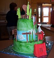View of back of cake which had rustic signs labeled with camp names.