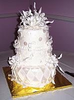 Fondant covered white whimsical cake with white gumpaste/sugarpaste edible decorations